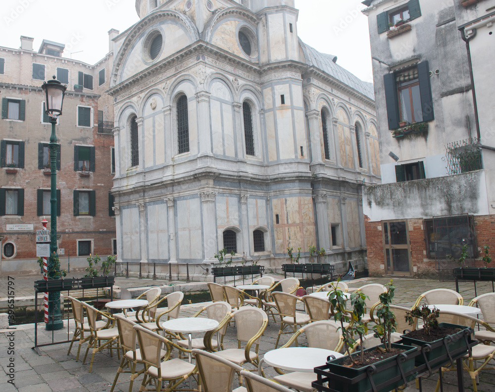 Naklejka premium Beautiful romantic italian city Venice with ancient architecture. Empty cafe in city center at the winter morning