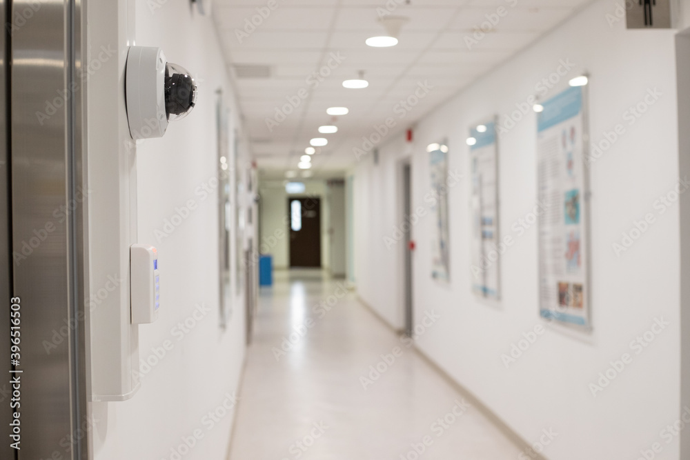 Security surveillance system (camera and digital smart door lock) at the entrance to a modern office building or advanced laboratory with blurred corridor Security surveillance system (camera and digital smart door lock) at the entrance to a modern office building or advanced laboratory with blurred corridor
