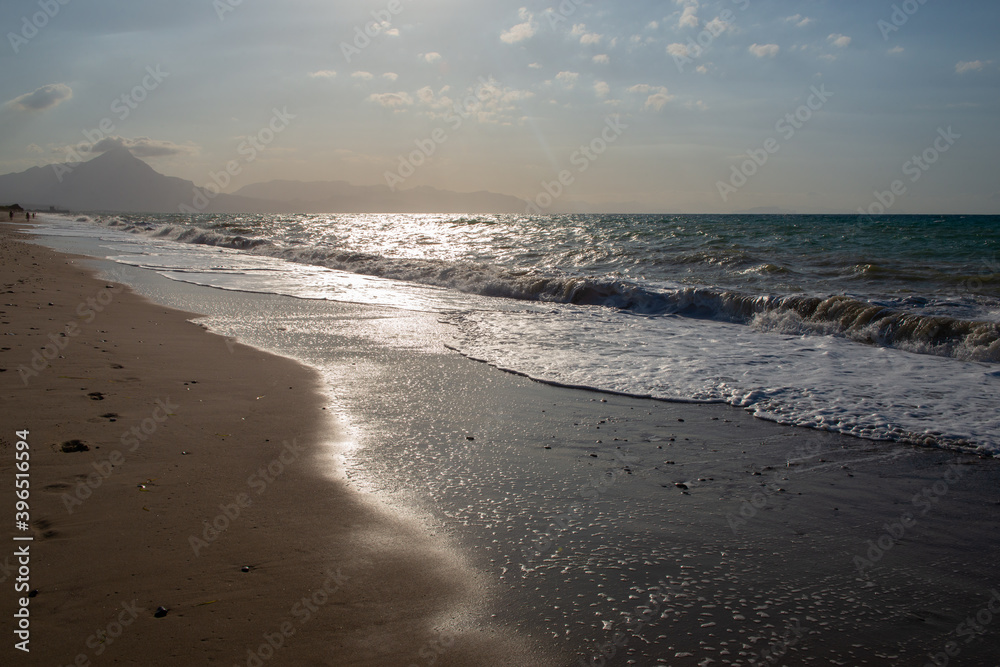 Beach at sunset in Sicily, Italy. Landscape with Mediterranean sea and mountains