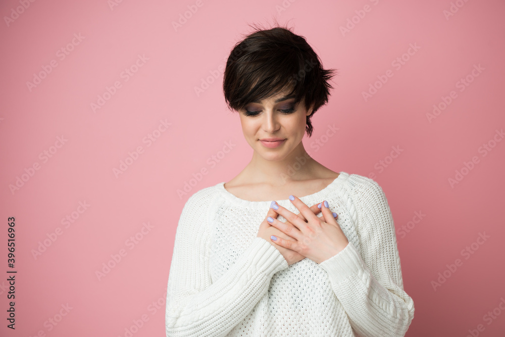 Young pretty woman smiling with hands on chest and grateful gesture on face, feels grateful, believes in success, wishes dream come true, visualizes future. Young pretty woman smiling with hands on chest and grateful gesture on face, feels grateful, believes in success, wishes dream come true, visualizes future.