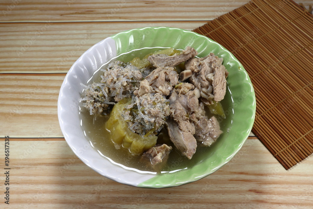 Clear soup of pork rib, minced pork and bitter gourd in the bowl. Famous traditional soft and easy digestion menu in Asia restaurant. Clear soup of pork rib, minced pork and bitter gourd in the bowl. Famous traditional soft and easy digestion menu in Asia restaurant.