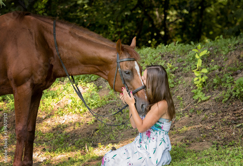 Love and Understanding Between Girl and Horse. Blondie Girl and Brown Horse in the City Park.