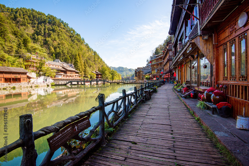 Tourists walking along Phoenix Ancient Town (Fenghuang County). Awesome view of scenic old street. Fenghuang is a popular tourist destination of Asia.