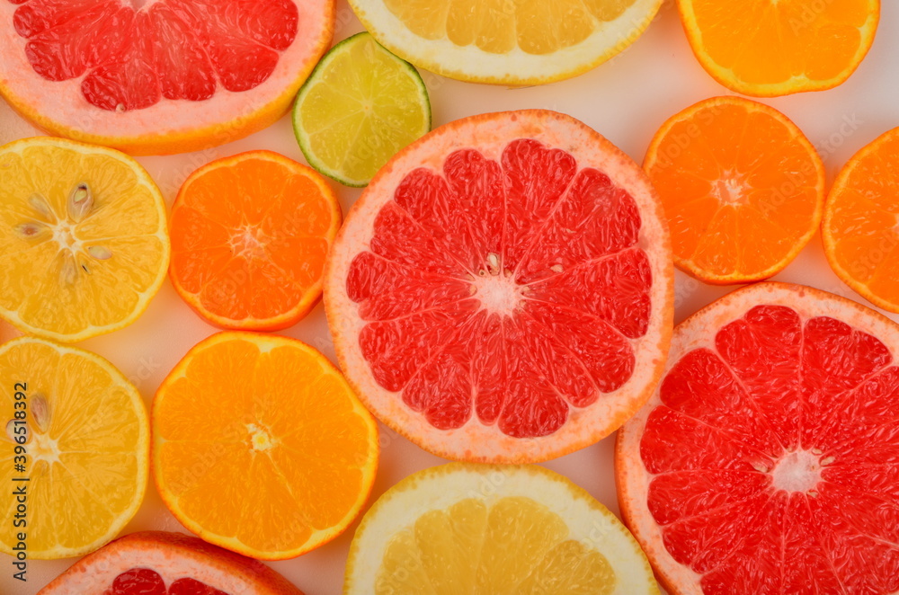 Sliced citrus fruits background. Red grapefruit, oranges, lemons, lime, mandarins Sliced citrus fruits background. Red grapefruit, oranges, lemons, lime, mandarins