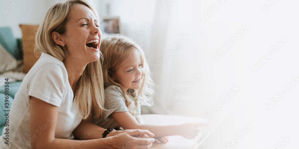Mom and daughter watching a cartoon on a digital tablet Mom and daughter watching a cartoon on a digital tablet