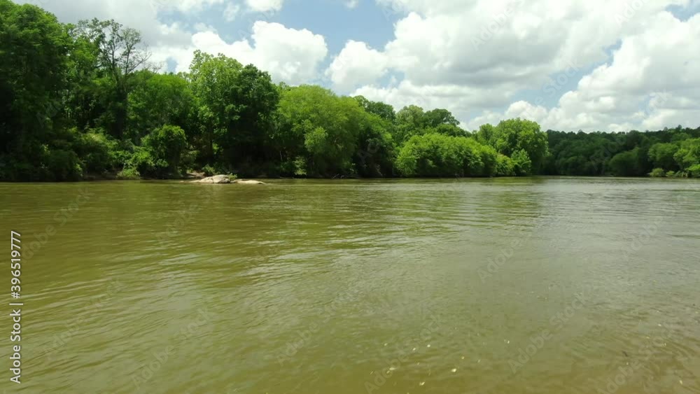 Chattahoochee river in Georgia with blue sky, clouds and reflections on the water
