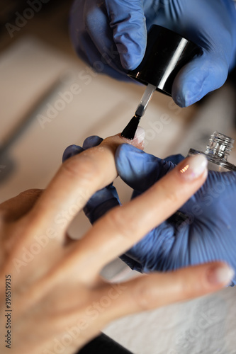 Closeup shot of a woman in a nail salon receiving a manicure by a butician