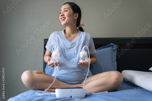 Mom use electric breast pump feeding for her baby.