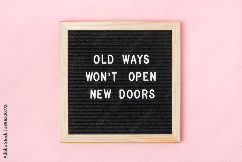 Fototapeta Old Ways Won't Open New Doors. Motivational quote on black letter board on pink background. Concept inspirational quote of the day. Greeting card, postcard