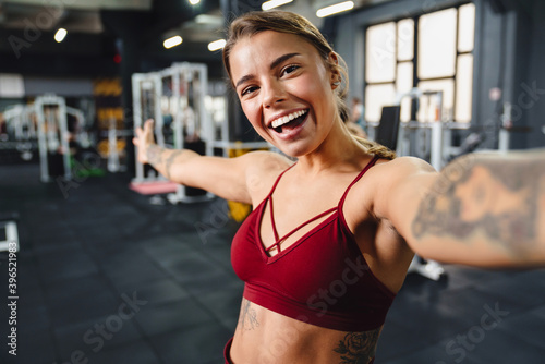 Excited athletic sportswoman showing copyspace while taking selfie