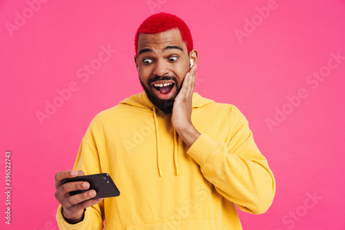 Surprised african american guy in earphones using mobile phone © Drobot Dean