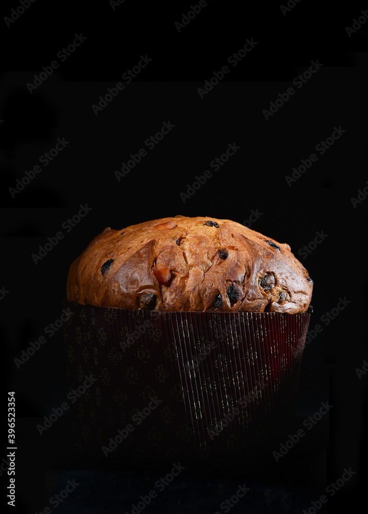 artisanal panettone typical from Milano area on black background whit cutting light - obrazy, fototapety, plakaty 