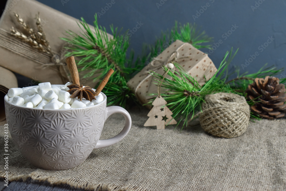 Large coffee mug with marshmallows and spices on the background of objects for gift wrapping Large coffee mug with marshmallows and spices on the background of objects for gift wrapping