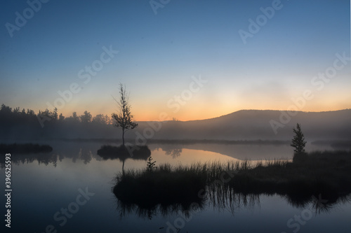 Sunrise on czech moorland lakes with fog over the water