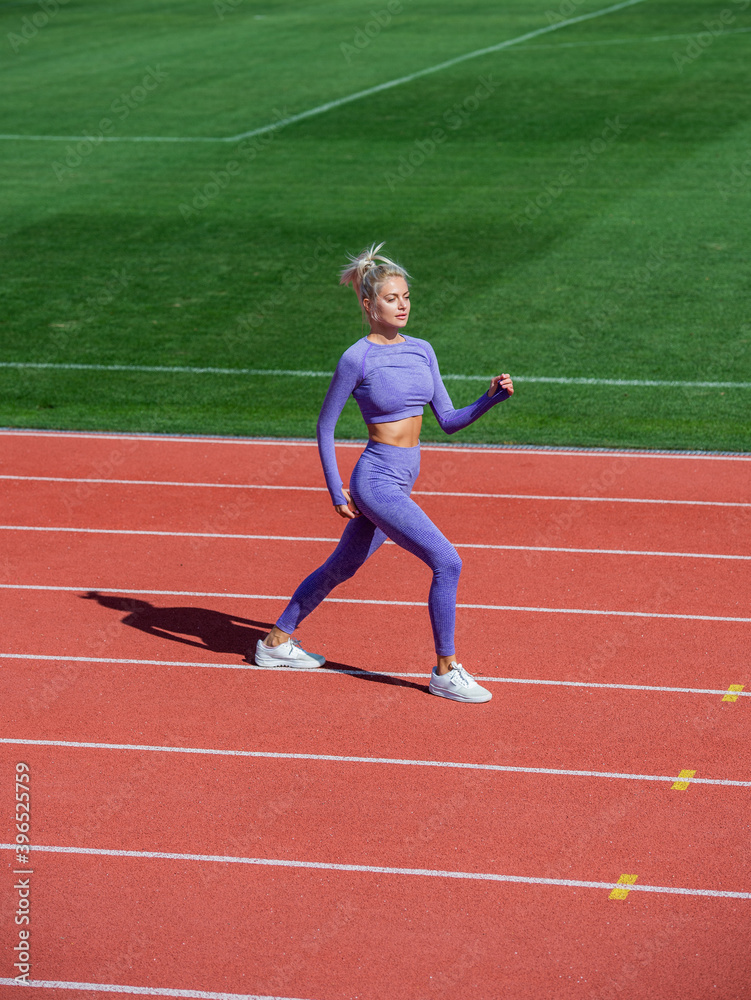 sexy fitness woman in sportswear. athletic lady warming up on stadium running track. female athlete do sport workout. trainer or coach training. perfect body shape. healthy and sporty