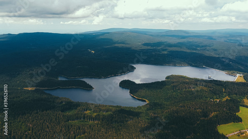 Dam surrounded by forests and mountains and clouds in the sky
