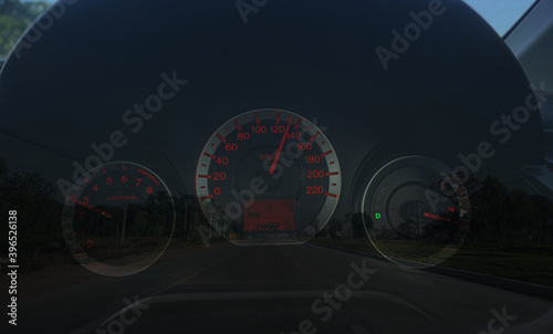 Speedometer 110 kilometre over a blurred road representing driving very fast Evening background. © Richman Photo