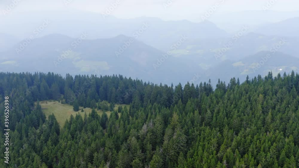 A pan drone shot of a foggy forest on the mountain at Sostanj, Slovenia. A pan drone shot of a foggy forest on the mountain at Sostanj, Slovenia.