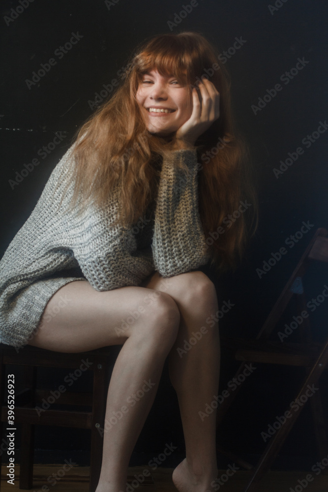 ginger woman sitting on chair and smiling ginger woman sitting on chair and smiling