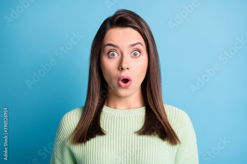 Photo of charming young girl open mouth surprised look staring camera wear green sweater isolated blue color background © deagreez