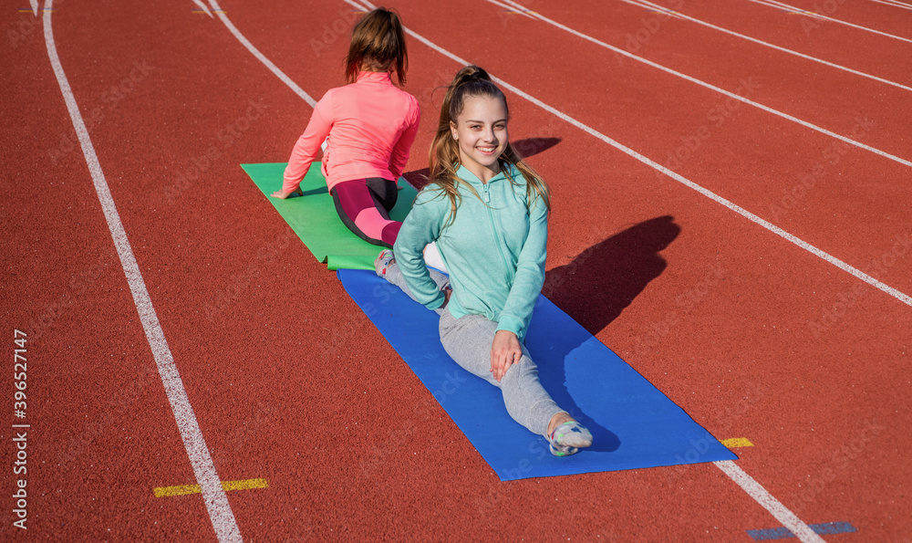 Obraz premium gymnasts prepare for competition. athletes warm up on stadium gym. split flexibility. children training at school physical lesson. teenage girls stretching before training. Everything is possible