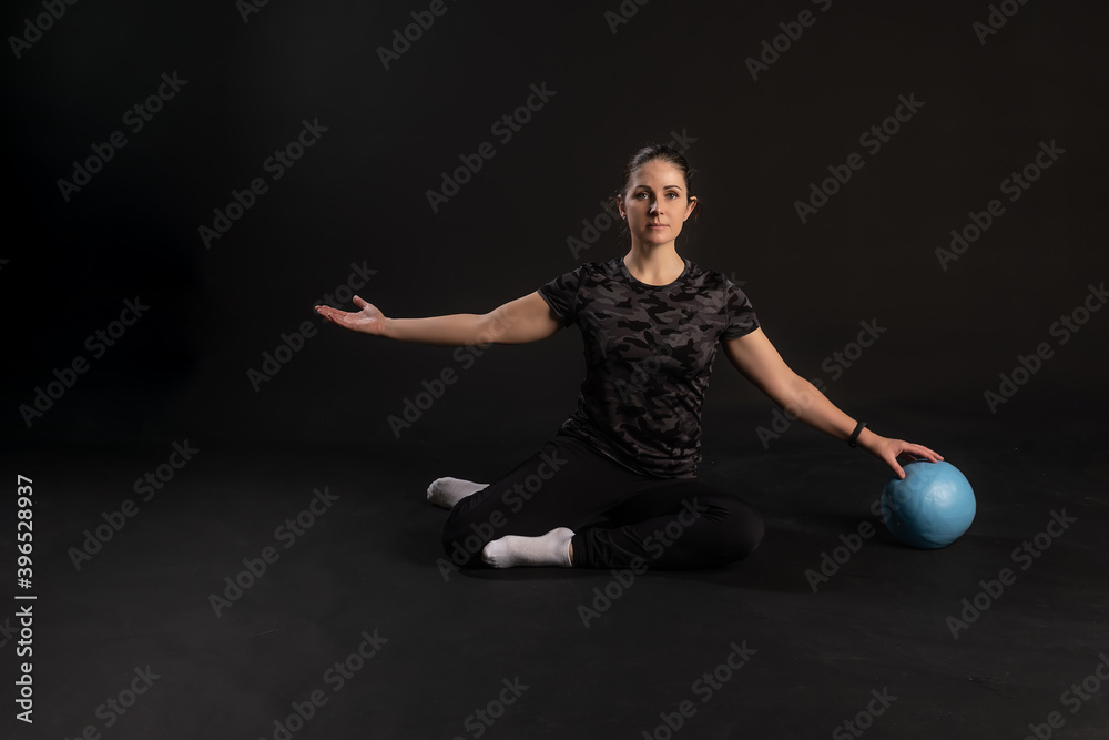 Fitness girl with Aqua ball, doing exercises. Engaged in sports on a black background Happy with a good look Fitness girl with Aqua ball, doing exercises. Engaged in sports on a black background Happy with a good look