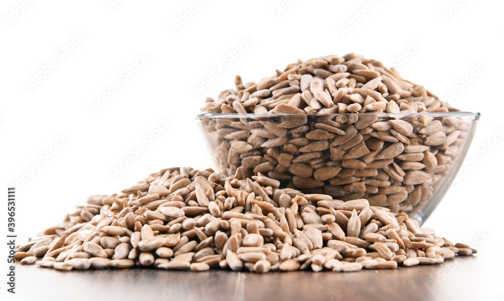 Obraz premium Bowl of shelled sunflower seeds isolated on white