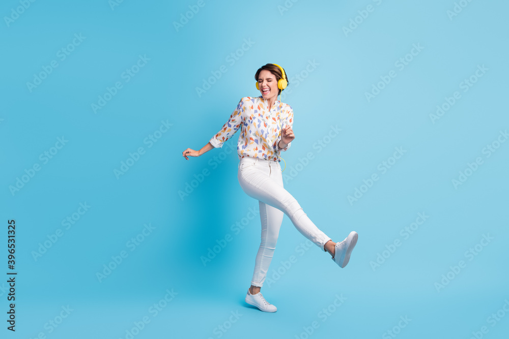 Full body photo of young girl happy smile excited have fun enjoy listen music earphones dance isolated over blue color background