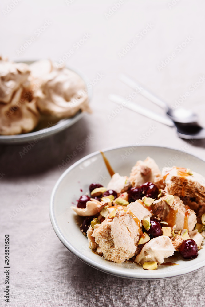 Not traditional Eton mess. Meringue, pistachio, cherry and caramel sauce dessert. Selective focus Not traditional Eton mess. Meringue, pistachio, cherry and caramel sauce dessert. Selective focus