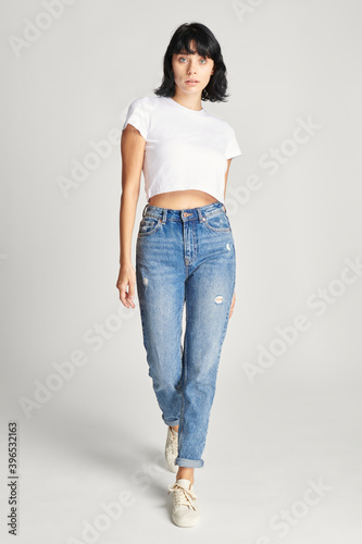 Woman in white crop top and high waisted jeans full body shot
