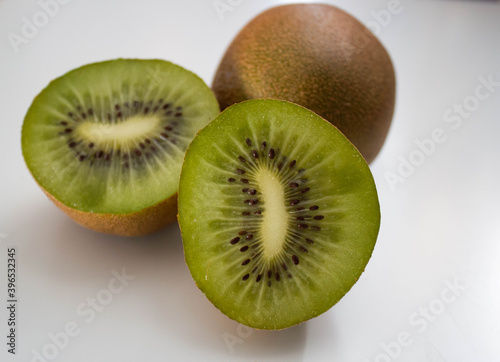 one whole kiwi and 2 kiwi halves on a white background. High quality photo