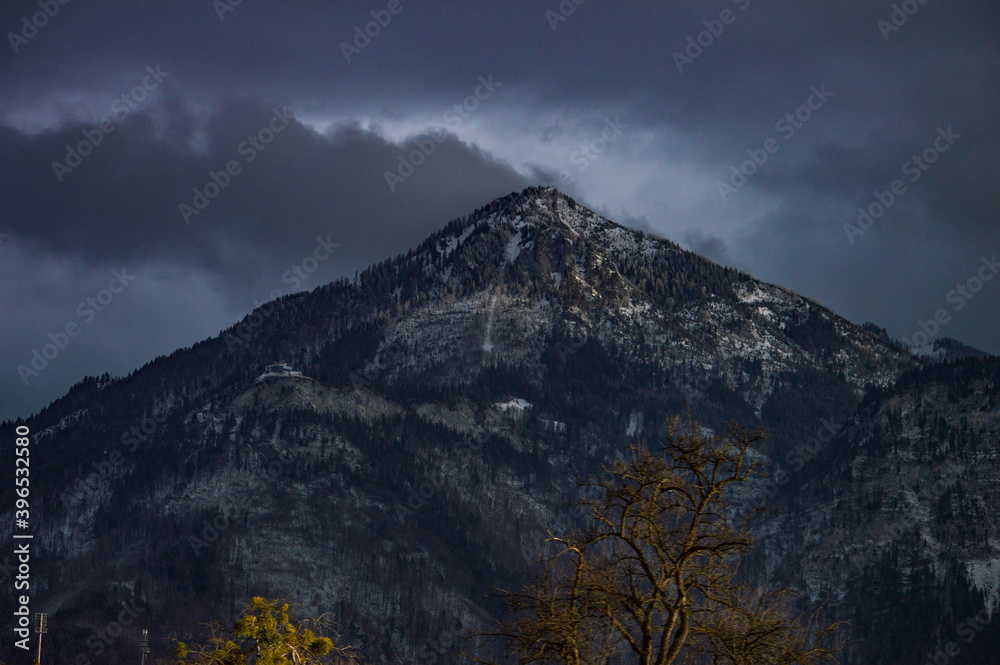 Scenic view of the mountain with trees under the dramatic cloudy sky