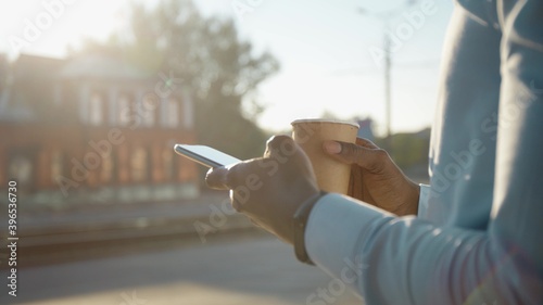 Close up african american young attractive man using phone on street sunlight sunset cellphone computer fashion internet face outside technology businessmen black young city mobile