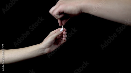 A woman holds a burning match while a man puts out a match with his fingers. 4k © Vital9c