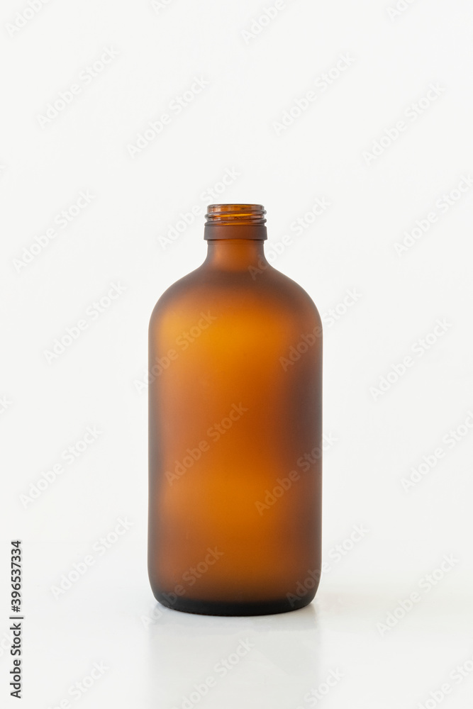 Empty brown glass bottle on off white background Empty brown glass bottle on off white background