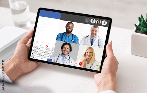 Doctors Having Online Meeting Via Video Call On Tablet Indoor