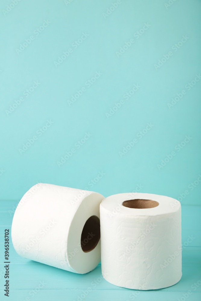Obraz premium Roll of toilet paper on blue background, top view.