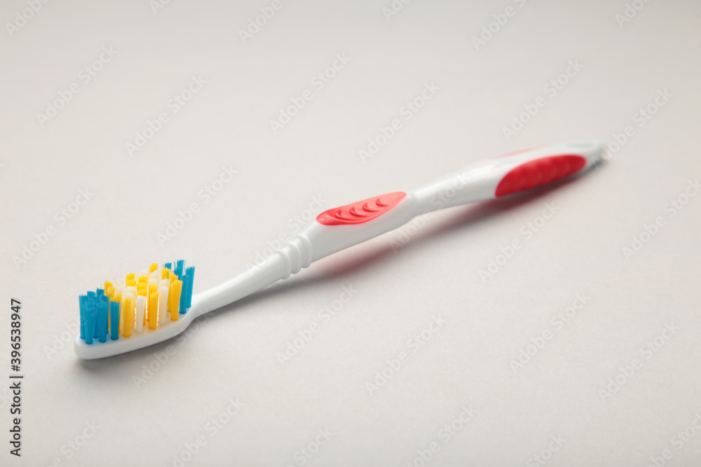 Red toothbrush on a grey background with copy space Red toothbrush on a grey background with copy space