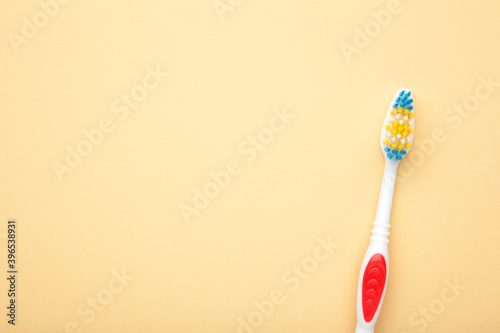 Red toothbrush on a beige background with copy space