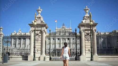 A young woman walks in front of the Royal Palace in Madrid, Spain