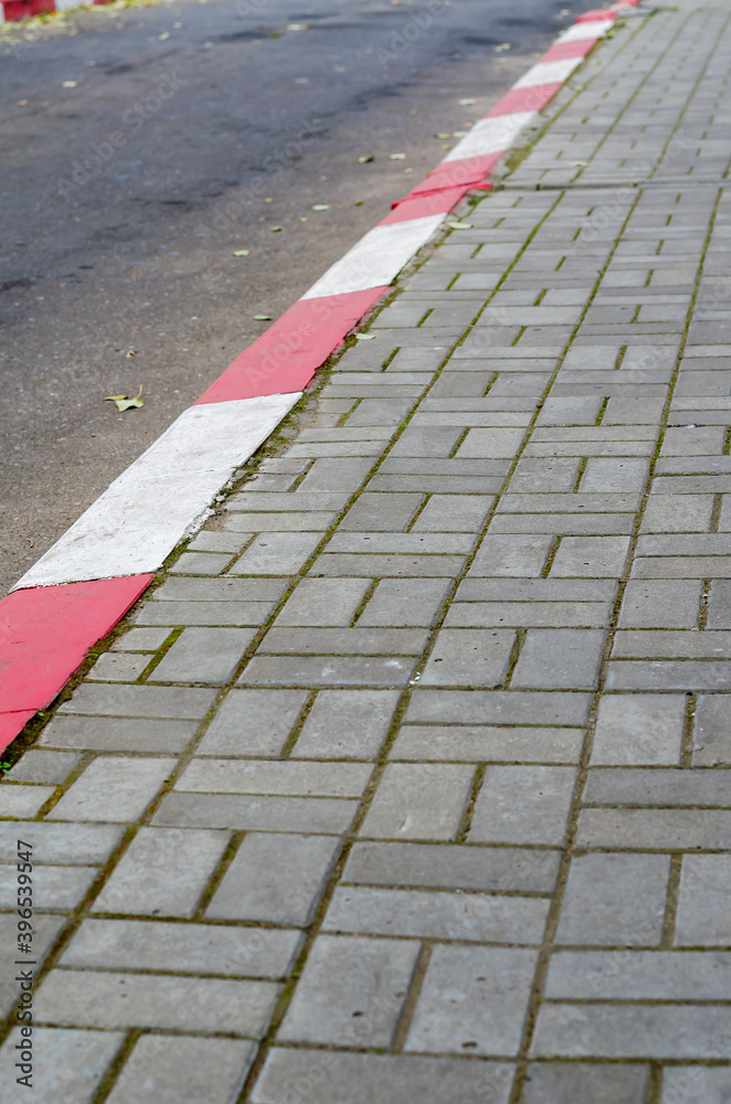 White and red strip no parking sign on footpath road.