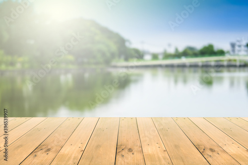 Wooden board empty table in front of blurred background. Perspective brown wood over blur river with flare background - can be used for display or montage your products.Mock up for display of product.