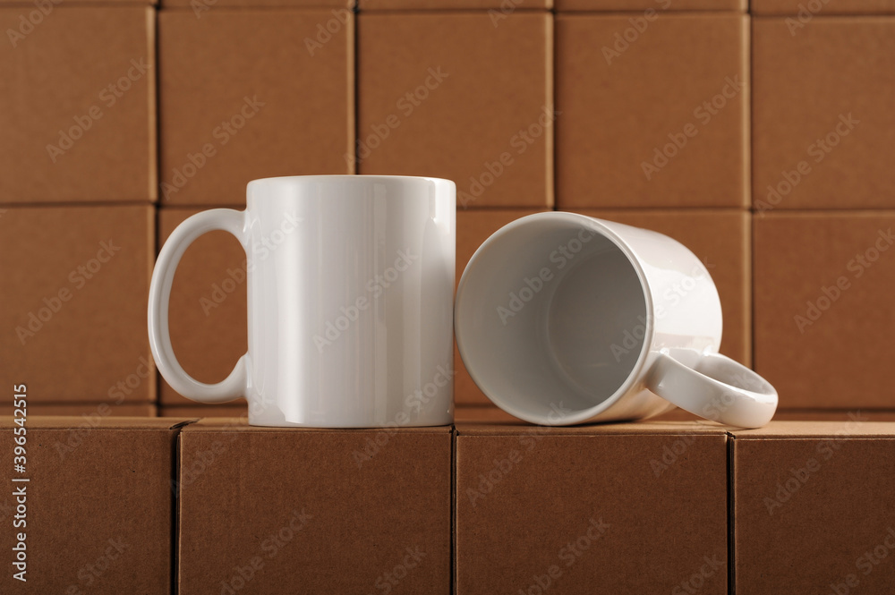 two white mugs for sublimation on the background of cardboard craft boxes two white mugs for sublimation on the background of cardboard craft boxes