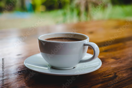 .A cup of coffee on a wooden table in a coffee shop