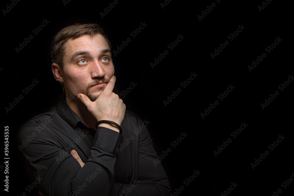 Closeup portrait of handsome man with a beard in black shirt. Isolated on black background Closeup portrait of handsome man with a beard in black shirt. Isolated on black background