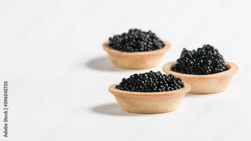 black caviar on a white plate. tartlet with black caviar. snack.
black caviar on a white plate. tartlet with black caviar. snack.