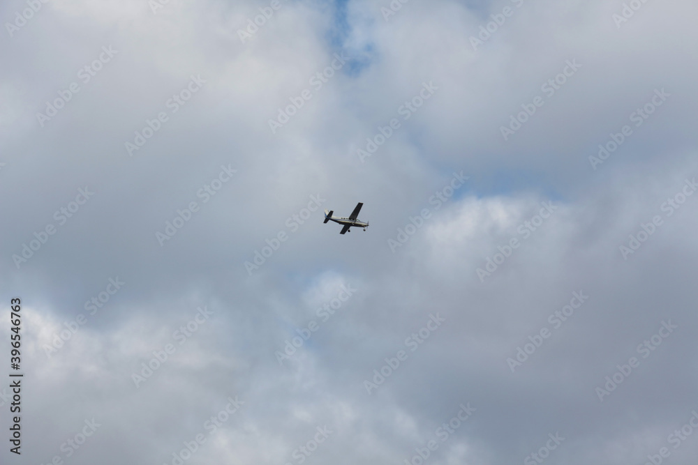 Small propeller-driven aircraft against the background of the cloudy sky Small propeller-driven aircraft against the background of the cloudy sky