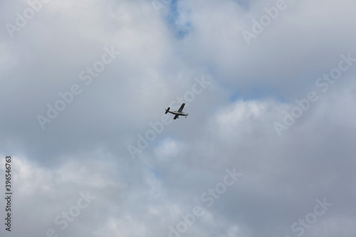 Small propeller-driven aircraft against the background of the cloudy sky