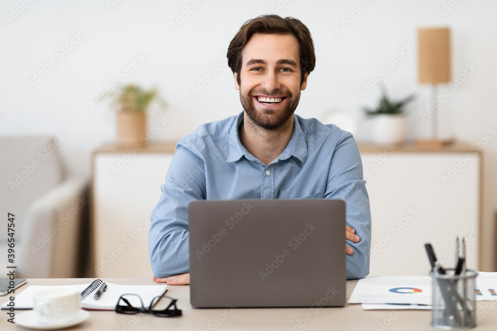 Happy Entrepreneur At Laptop Smiling To Camera Sitting At Workplace