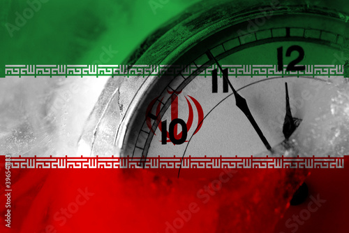 Iran, Iranian flag with clock close to midnight in the background. Happy New Year concept